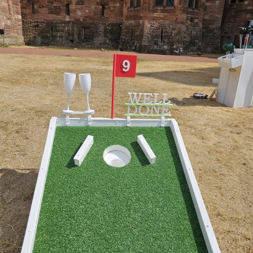 clinging glasses together and well done sign on mini golf course to celebrate your special wedding day and to say you have completed the course.