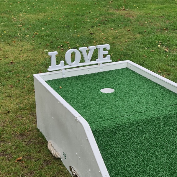 Love sign clipped onto mini golf course to hire for your wedding day,